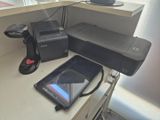 une tablette posée sur un bureau, à côté d'une imprimante