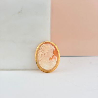 pièce plaquée or posée sur un bloc de marbre, sur fond rose et blanc