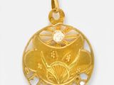 un gros plan d'un pendentif en or orné d'une fleur