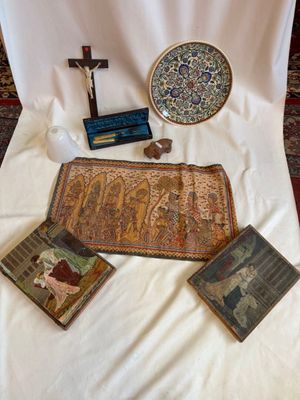 several religious items are displayed on a white cloth on a table