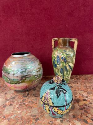 two vases sitting on a table with a red wall in the background