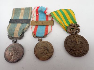 three medals are sitting on a table with a ribbon around them