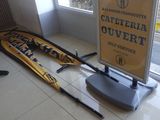 une pancarte indiquant « Cafferia Ouvertt » posée à côté d'une paire de skis posée par terre