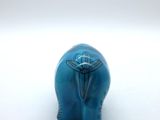 a small blue elephant figurine sitting on a white surface