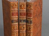 two old books sitting on top of each other on a table