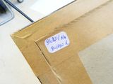 une boîte en carton avec un autocollant posé sur le sol
