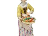 une image représentant une figurine de femme tenant un panier de légumes