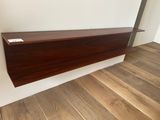 the shelf is made out of wood and has a white label on it
