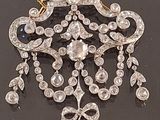 an image of a diamond and gold broochle on a black surface