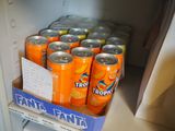many cans of orange soda in the fridge