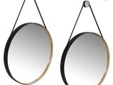 a pair of black and gold mirrors hanging on a wall