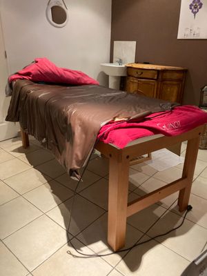 une table de massage recouverte d'une serviette, dans une pièce