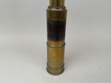 a gold and black cylinder shaped object on a white surface
