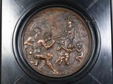 plaque en bronze représentant un groupe de personnes jouant au baseball dans un champ
