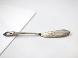 silver spoon on a white surface with a small spoon sticking out of it