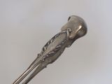 a silver spoon with a bird on it sitting on a table