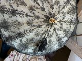 un parapluie noir et blanc posé sur une chaise en bois