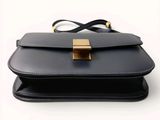 black leather handbag with a gold clasp on a white background
