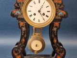 une horloge posée sur un socle, sur fond bleu