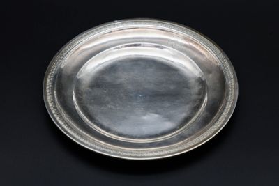 un plat ancien en argent orné d'un motif décoratif sur fond noir