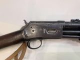 an old gun on display on a table with a leather strap