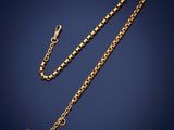 a gold necklace with a cross on a chain