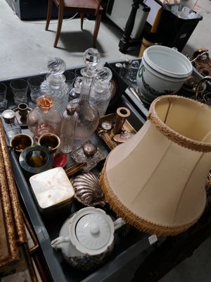 une table sur laquelle se trouvent une lampe et de nombreux objets