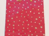 sac cadeau rouge orné d'étoiles dorées sur fond blanc