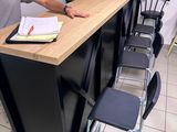 un homme debout devant un comptoir, un livre à la main
