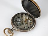a pocket watch that is open on a white surface