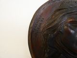 a close up of a bronze head of a woman