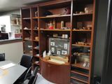 une table et des chaises dans une pièce où se trouve une bibliothèque fixée au mur