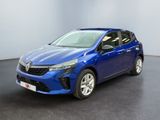 Une voiture bleue est garée dans une pièce au sol noir.