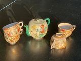 trois théières et deux tasses posées sur une table