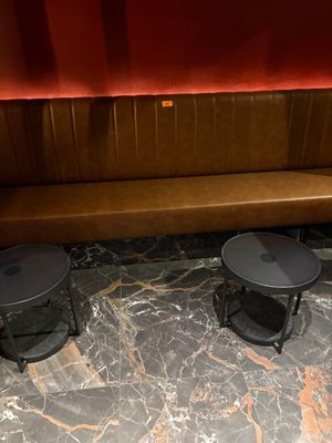 deux tables et un banc dans un coin de la pièce