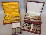 two sets of silverware in a case on a table