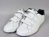 des baskets Adidas blanches avec des finitions noires et des semelles blanches sur un fond blanc