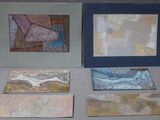 several pieces of art are displayed on a table next to each other