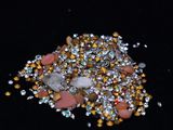 a close up of a person ' s hand holding a pile of gold and silver crystals
