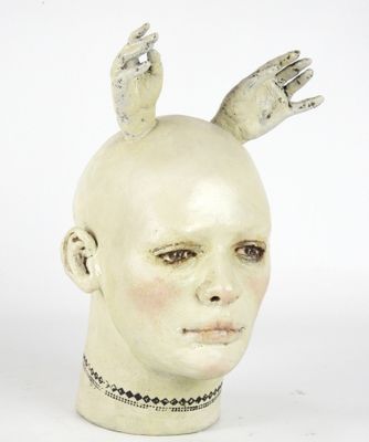 a sculpture of a head with two hands on top of it