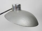 a silver lamp that is on a white table