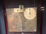 a clock that is sitting in a case on the floor