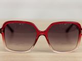 sunglasses on a wooden table with a white wall in the background