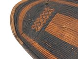 a brown and black woven basket on a white surface