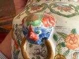 a person holding a vase with a handle in their hand