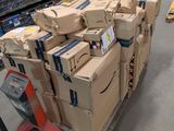 Les cartons sont empilés sur un chariot dans un grand entrepôt