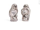 two silver figurines of two birds with chinese writing on them