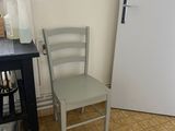 a white refrigerator and a chair in a small room
