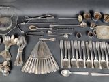 a lot of silver spoons and spoons on the table
