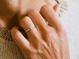 a woman with a ring on her neck and a ring on her hand